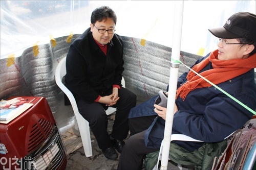 정재식(좌) 대형마트 규제 대책위 사무국장과 홍기욱씨가 천막 안에서 이야기를 나누고 있다.